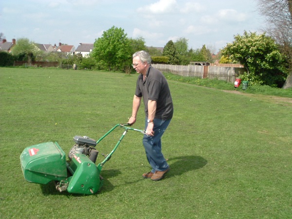 Ian Crisp using the mower to prepare the wicket